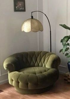 a living room with a green chair and potted plant