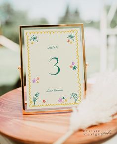 the table numbers are placed on top of a wooden stand with white feathers in front of it