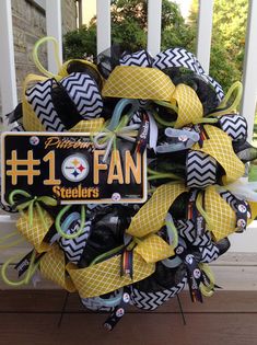 a football wreath with the number one fan on it is sitting in front of a porch