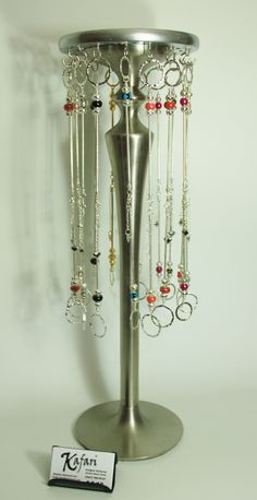 a silver jewelry stand with lots of necklaces hanging from it