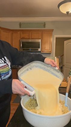 a person pouring batter into a large bowl