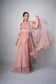 📌Hey! Please message us if you have any questions. We'll definitely assist you. This Organza Pre Draped Pink Ruffle Saree is a lovely and sophisticated saree composed of top-notch organza fabric in an exquisite pink shade. The pre-draped saree is simple to wear and ideal for individuals who might not be familiar with the traditional draping method. The saree's ruffle embroidery lends it a touch of femininity and sophistication, making it the ideal option for formal events like weddings, celebrations, and other special occasions. You can personalize and create your own appearance by using the matching blouse that is included with the saree. The saree's lightweight material makes it pleasant to wear, and the elaborate embroidery and details raise its allure. You will definitely stand out in Paithani Gown, Pink Ruffle Saree, Organza Ruffle Saree, Black Ruffle Saree, Pink Organza Saree, Farewell Sarees, Haldi Outfit, Reception Outfit, Ruffle Saree