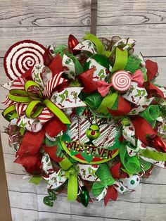 a christmas wreath with candy canes and candies hanging on a door hanger