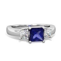 a three stone ring with two princess cut diamonds on each side and a blue sapphire in the center