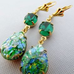 "These gorgeous earrings feature vintage glass opals and genuine Swarovski emerald colored rhinestones. The teardrop opals sparkle in shades of green, blue, gold and silver and measure 18x13mm (3/4\" x 1/2\") with a total drop of 51mm (2\"). I have handset the stones in gold plated prong settings and hung them from gold plated surgical steel, hypo-allergenic gold ear wire Please note: Each opal stone is unique, while all have the same beautiful colors each one displays a different pattern. I do Opal Earrings Vintage, Earrings Emerald, Green Opal, Earrings Green, Emerald Earrings, Swarovski Earrings, Emerald Jewelry, Opal Earrings, Earrings Vintage