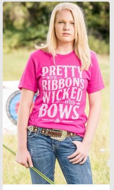 a woman wearing a pink shirt with the words pretty, ribbons, kicked and bows on it