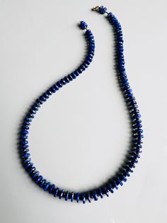 Greet our eye-catching lapis & black spinel necklace. This chic piece is finished with 14k gold clasp and findings for an extra dose of luxe. An elegant choice, but also perfect for layering with other necklaces for a stylish look. Suitable for any occasion, whether for a formal event or a festive gathering. lapis lazuli black spinel 14k gold clasp + findings shipping : allow up to a week from the date your order was placed for your necklace to ship Sapphire Colored Lapis Lazuli Round Bead Jewelry, Sapphire-colored Lapis Lazuli Round Beaded Jewelry, Sapphire Lapis Lazuli Jewelry With Faceted Details, Sapphire Colored Lapis Lazuli Single Strand Necklace, Sapphire Single Strand Lapis Lazuli Jewelry, Sapphire Lapis Lazuli Beaded Necklace, Sapphire Single Strand Necklace In Lapis Lazuli, Sapphire Color Single Strand Lapis Lazuli Jewelry, Blue Lapis Lazuli Polished Beads Jewelry