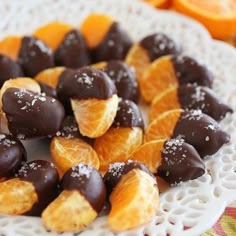 oranges and chocolate covered candies on a white plate