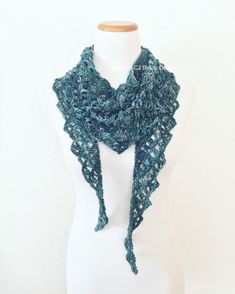 a white mannequin with a green crochet scarf on top of it