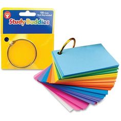 a stack of assorted colored paper with a gold ring on the front and side