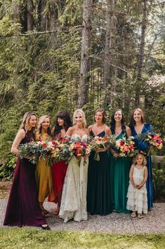 a group of women standing next to each other in front of trees