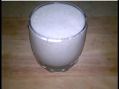 a glass filled with milk sitting on top of a wooden table