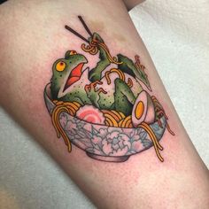 a tattoo on the leg of a person with food in a bowl and chopsticks