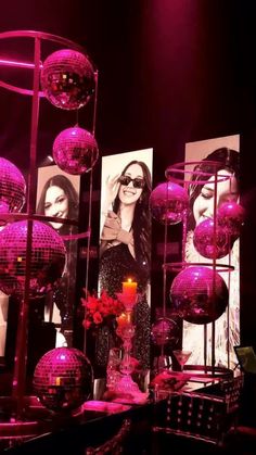 a table topped with lots of disco balls next to a candle and pictures on the wall