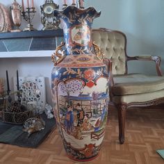 a large vase sitting on top of a wooden floor next to a chair and fireplace