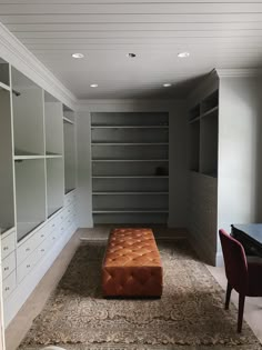 an empty walk in closet with leather bench