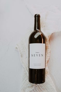 a bottle of wine sitting on top of a white blanket