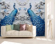 a living room with a couch and large wall mural depicting two blue peacocks facing each other