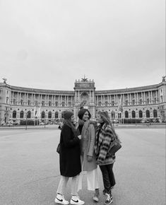 three girls standing in front of a large building