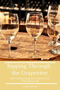 three wine glasses sitting on top of a wooden barrel with the words sipping through the grapevine