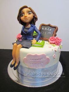 a cake that has a woman sitting on top of it with a chalkboard in the middle