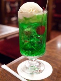 a tall glass filled with ice cream and green liquid