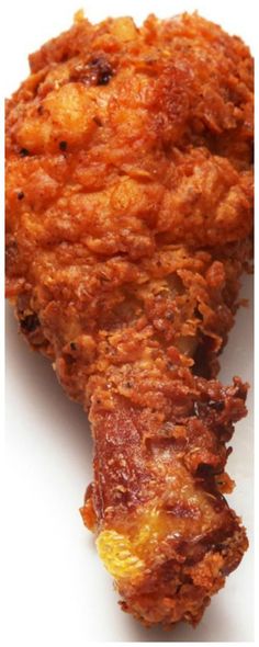 fried food on a white plate with a fork in the foreground and an image of chicken