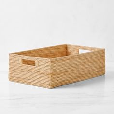 an empty wicker basket sitting on a white counter top, with the lid open