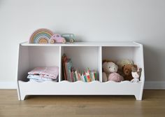 a white shelf with stuffed animals and books on it in a child's room