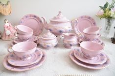 a table topped with lots of pink china