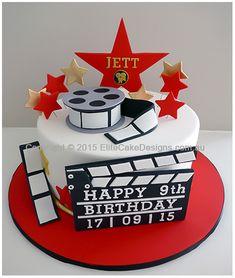 a birthday cake for a film director with stars and claps on top, sitting on a red plate