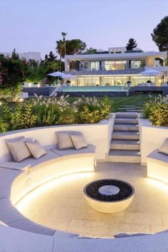 an outdoor seating area with stairs leading up to the top floor and lights around it