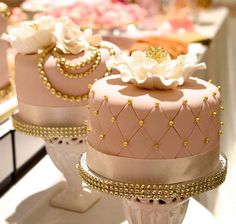 two pink cakes with gold decorations on them