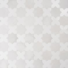 a white tiled wall with an arrow pattern on the top and bottom part, in shades of gray