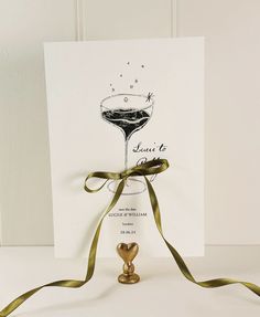 a greeting card with a martini glass on it and a ribbon tied around the front