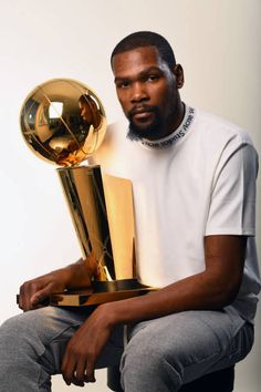 a man sitting on a chair holding a trophy