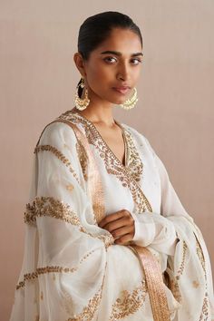 Off white long churidar sleeves straight kurta in organza base with blossom vine golden tone embroidery and sequin highlights. Paired with matching straight pant and floral embroidered dupatta.
Components: 3
Pattern: Embroidery
Type Of Work: Blossom Vine
Neckline: V
Sleeve Type: Long
Fabric: Organza
Color: Off White
Other Details: 
Attached inner lining
Approx. weight: 1500gms
Length: 
Kurta: 48inches
Pant: 40inches
Model Height: 5ft 9inches, wearing size XS
Note: The hair accessory worn by the Elegant Organza Palazzo Set For Navratri, White Salwar Kameez With Sheer Dupatta And Long Sleeves, Elegant White Churidar With Dabka Embroidery, White Long Sleeve Salwar Kameez With Sheer Dupatta, White Traditional Wear For Celebrations, White Long Sleeve Traditional Wear For Celebration, Elegant Long Sleeve Organza Churidar, White Organza Sharara With Dabka Detailing, White Organza Sharara With Dabka