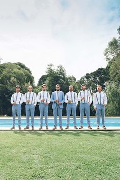 a group of men standing next to each other in front of a pool