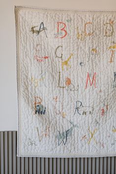 a baby quilt with letters and animals on it