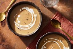 two bowls filled with soup on top of a wooden table