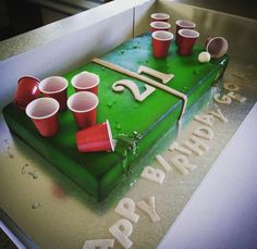 a green birthday cake with red cups on it