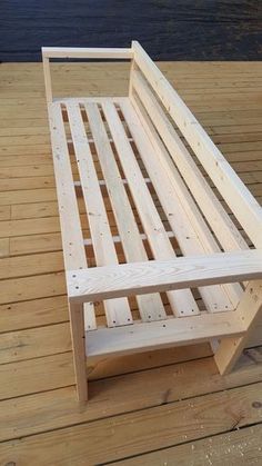 a wooden bed frame sitting on top of a wooden floor next to a body of water