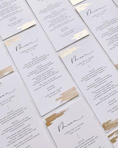 wedding program cards with gold foil on white paper and black ink are lined up in rows