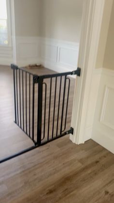 a room with hard wood floors and a black gate