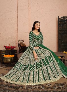 Dark Green Golden Zari Embellished Designer Anarkali Suit features a beautifully embellished attire with all the details of golden zari, thread and stone work in traditional kali patterns on soft net anarkali top paired with solid santoon bottom and zari border and butti embellished soft net dupatta. Style this set on any asian bridal or festive party with statement jewellery and heels to look stunningly gorgeous. This set comprises of an anarkali gown, pants bottom and a dupatta. Embroidery wor Long Anarkali Dress, Dress Anarkali, Green Anarkali, Long Anarkali, Designer Anarkali Suits, Gown Suit, Gown For Women, Designer Anarkali, Indian Wedding Wear