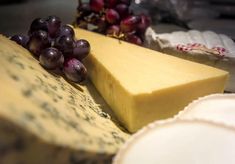 some cheese and grapes are sitting on a table