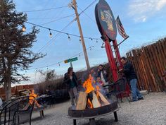 people are gathered around an outdoor fire pit