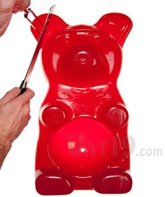 a person cutting into a plastic bear with scissors