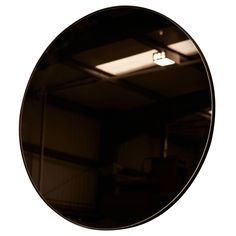 a round mirror hanging from the side of a wall