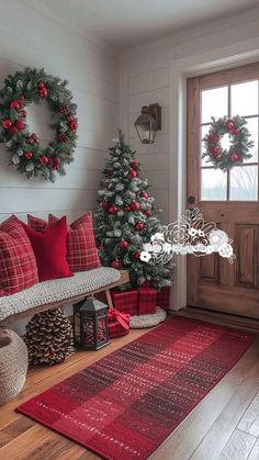 christmas decorations and wreaths are on display in the entryway, along with a red rug